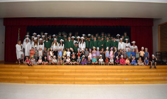 Seniors and PreK students posing on stage