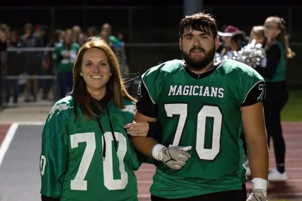 A Herkimer student dressed in a football jersey poses with his mother wearing a matching jersey.