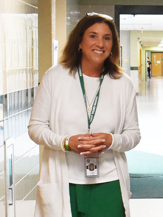 Superintendent Carney wearing the Herkimer green and white walks through the school halls.