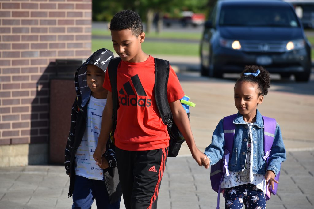 Three elementary students arriving on the first day of school