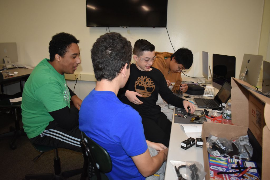 Four students working on building a drone.