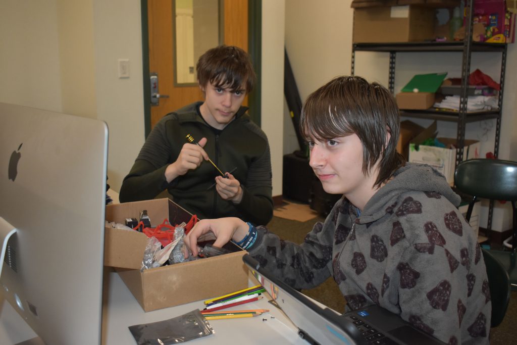 Two students working on building a drone.