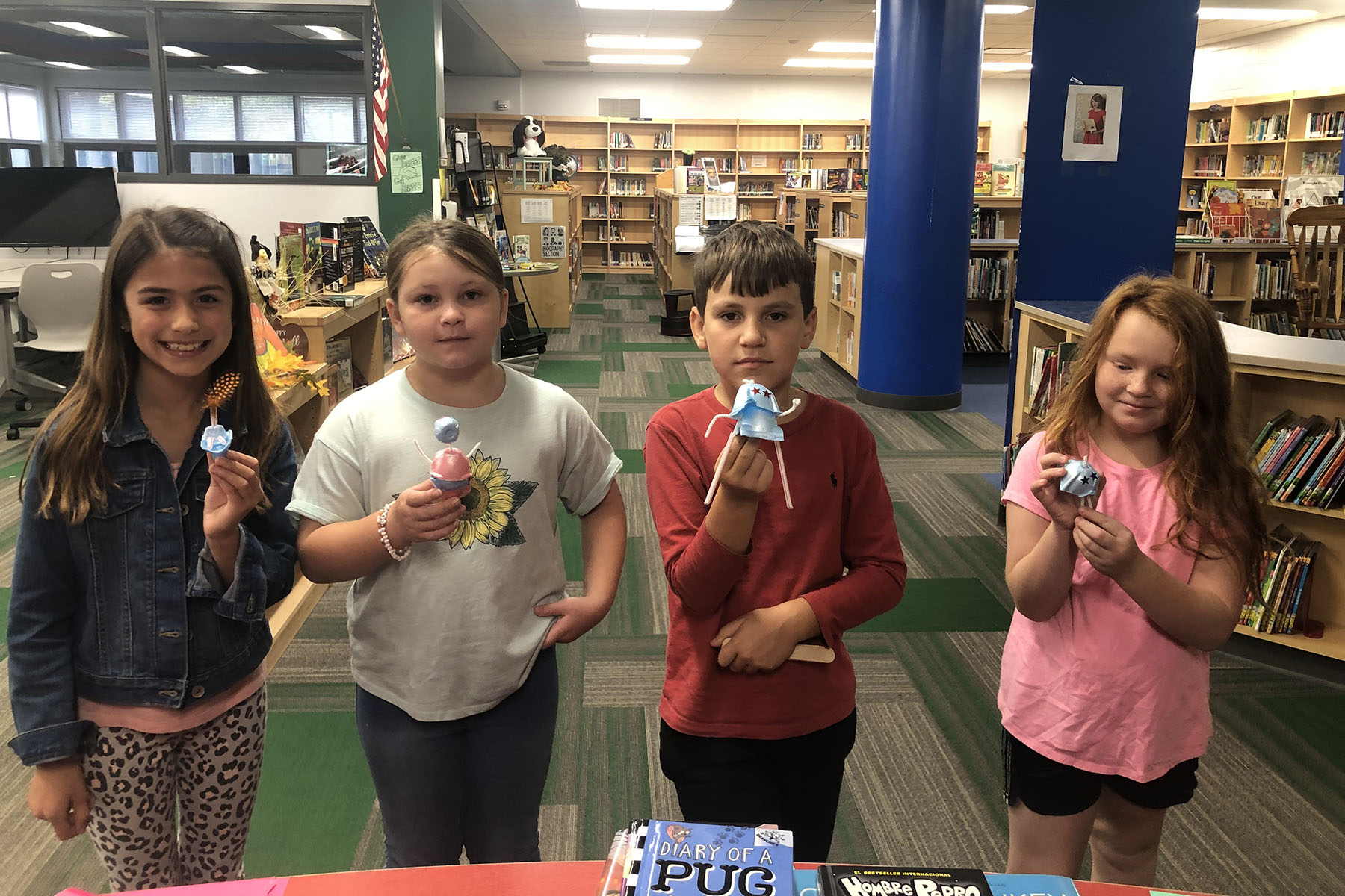 Four students posing with library projects