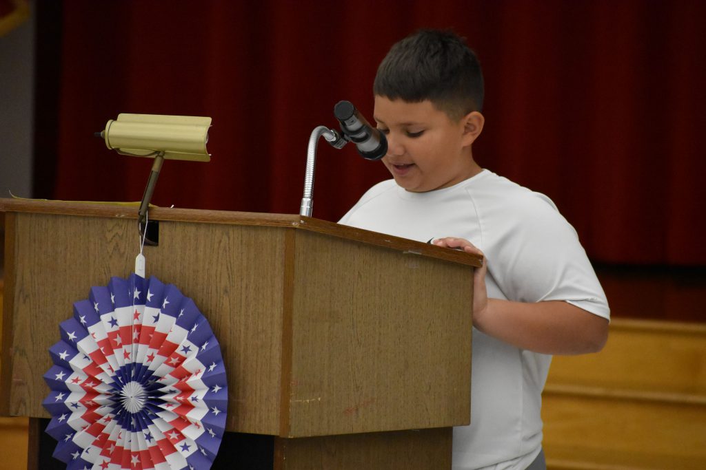 Student at podium speaking into a microphone