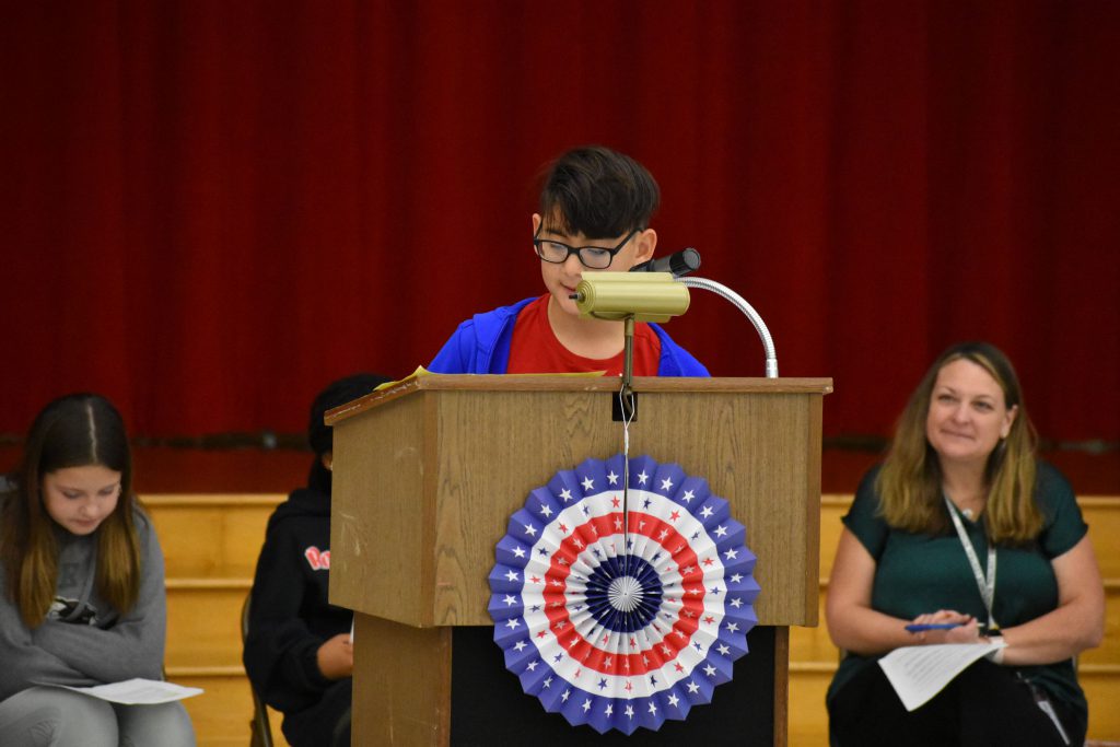 Student at podium speaking into a microphone