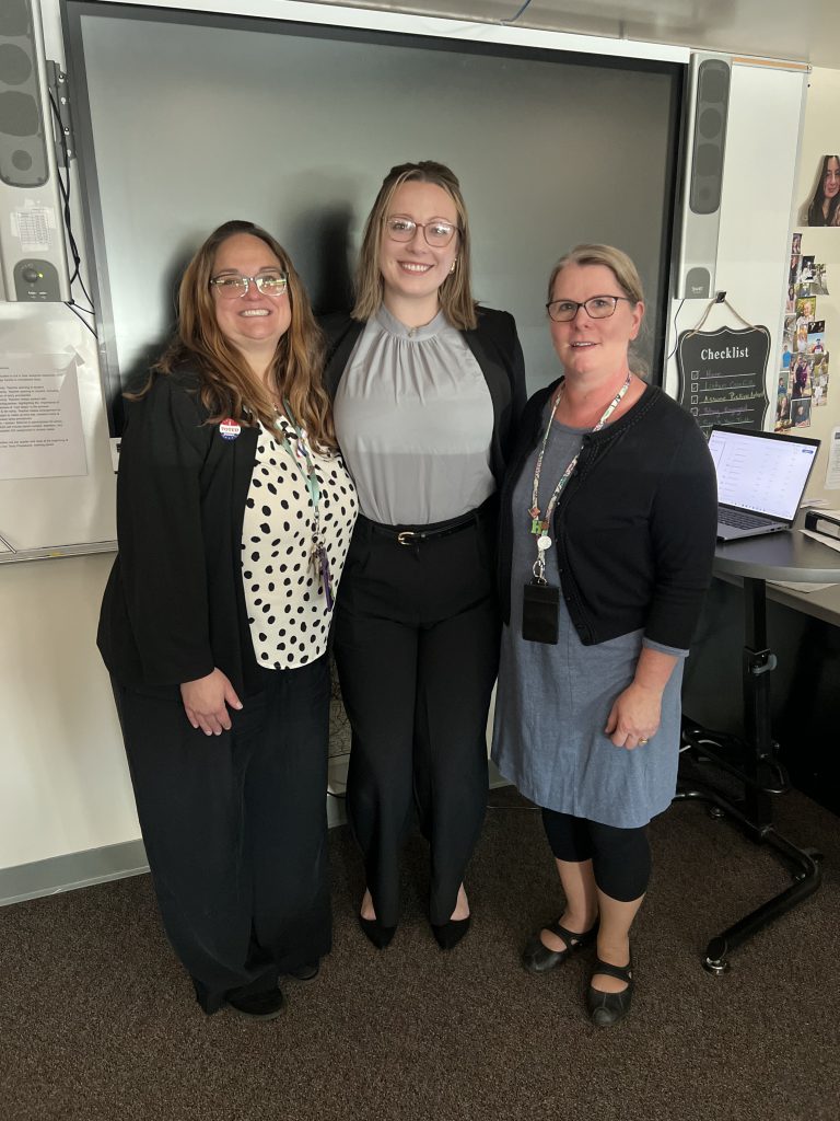 Laura Scalise, Chelsea Jory and Caroline Lampert pose together in a classroom.