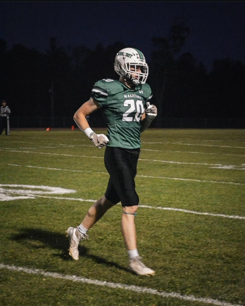 Student Kaleb Davis in his football uniform on a football field