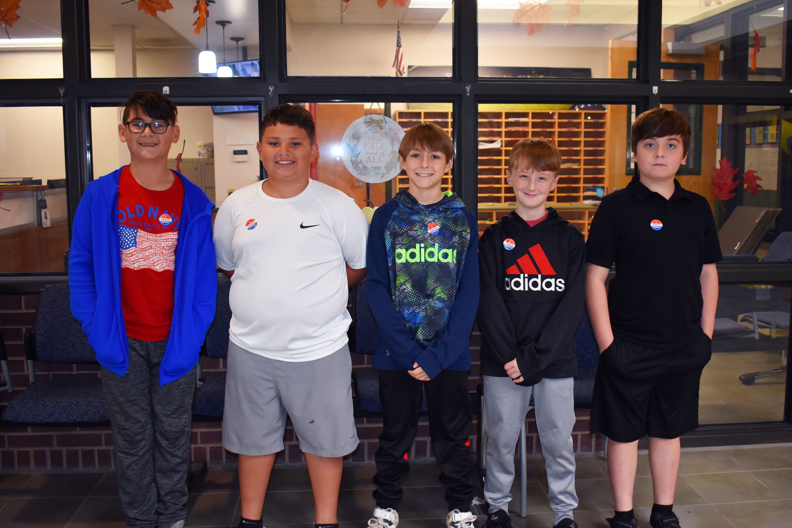 Five fifth graders who won election posing together in hallway