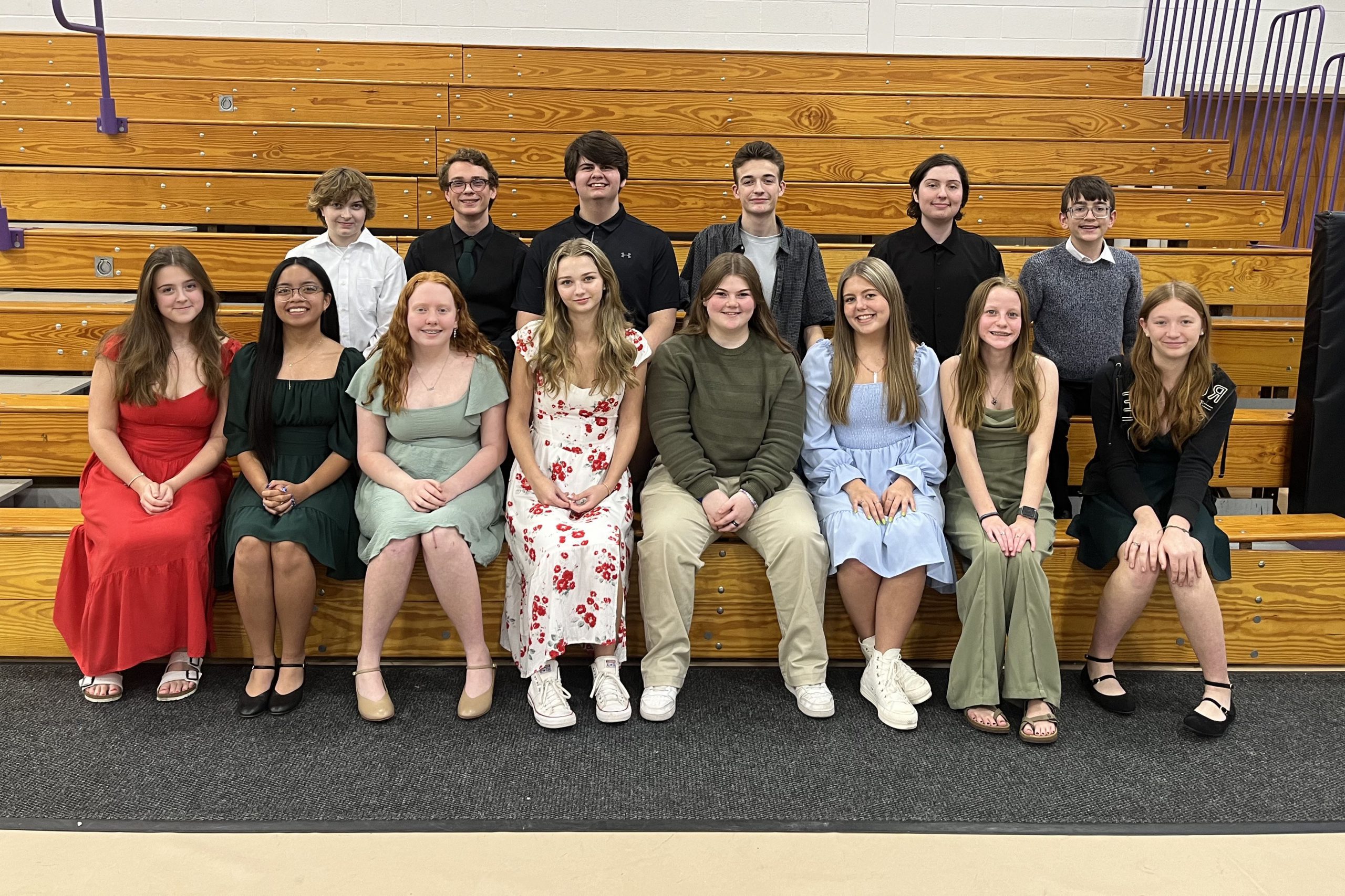 Students posing seated on bleachers