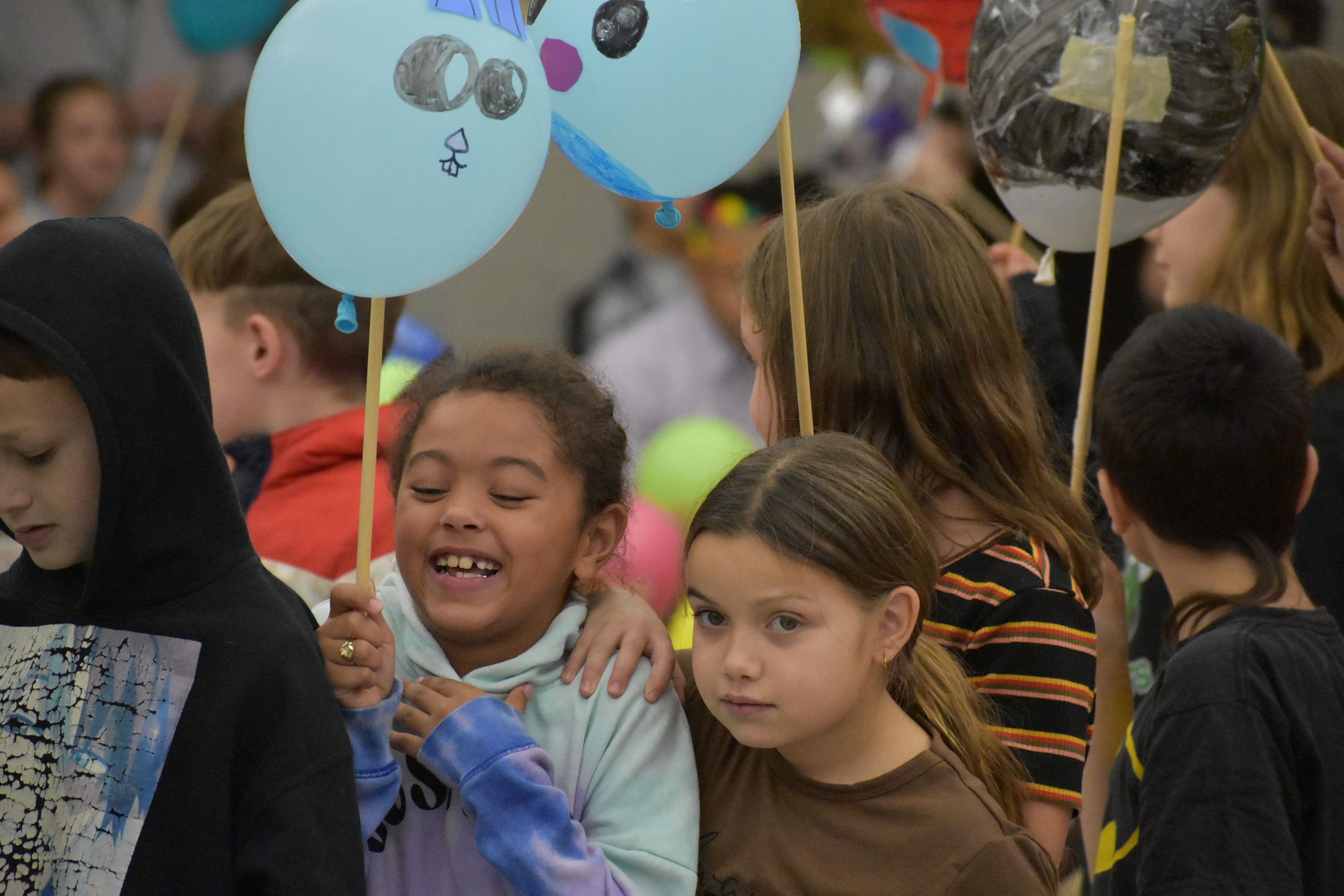 Students holding balloons for Thanksgiving parade