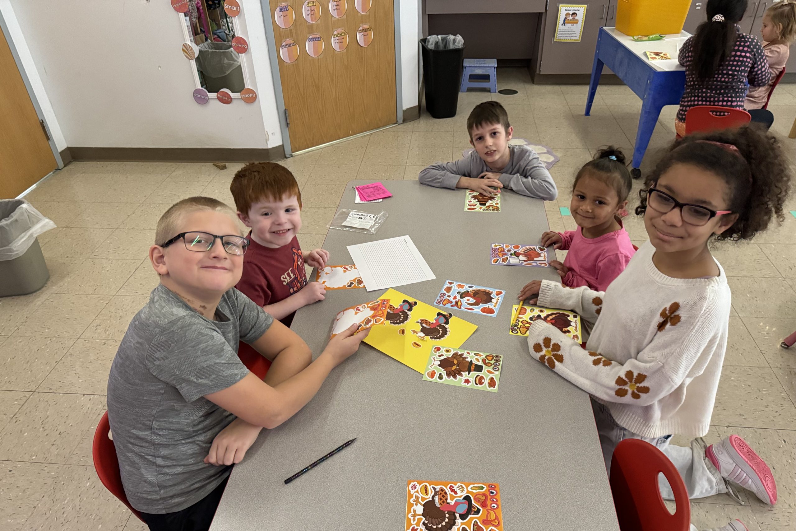 Five elementary students working at a table together