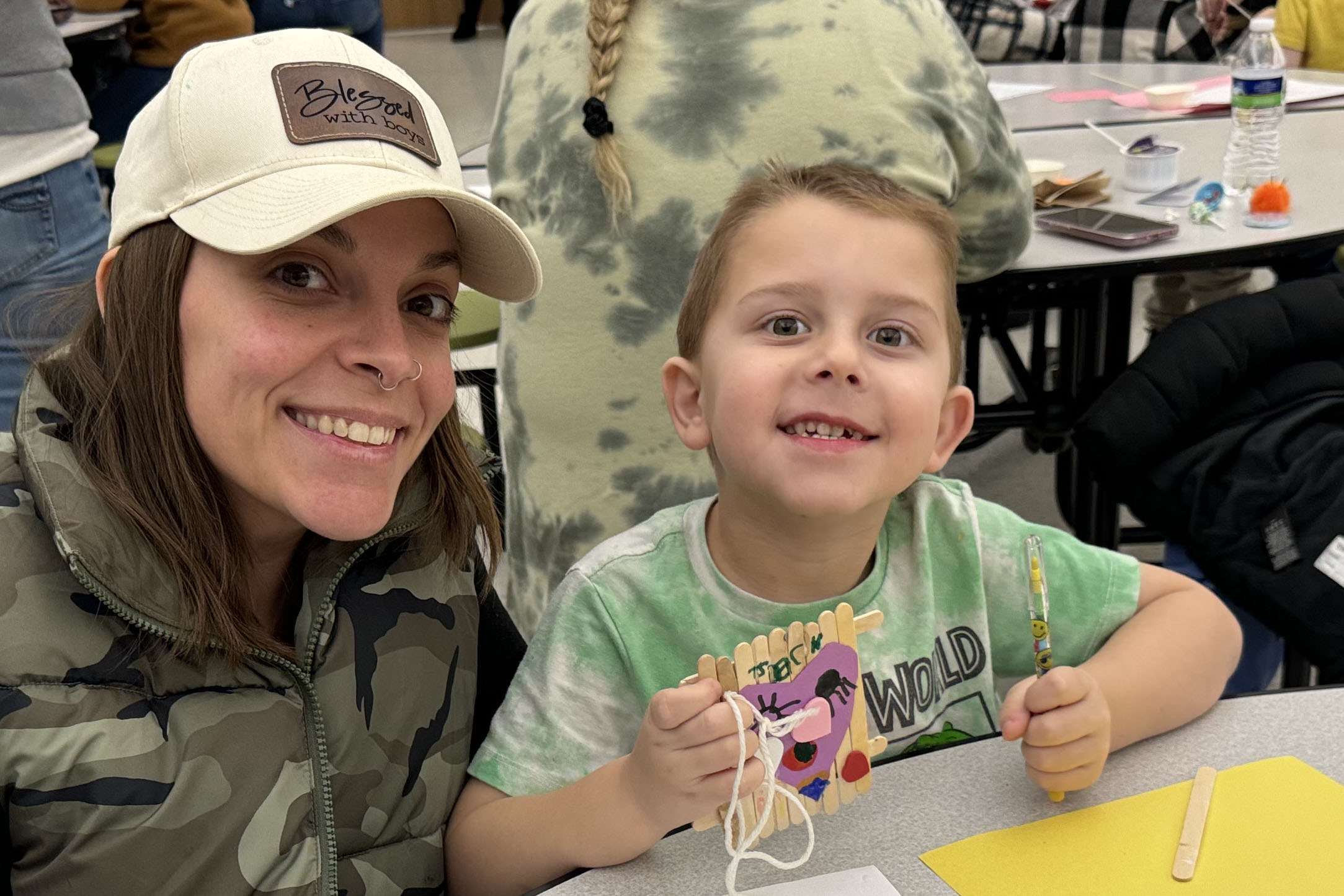 PreK student and adult doing Valentine's Day craft