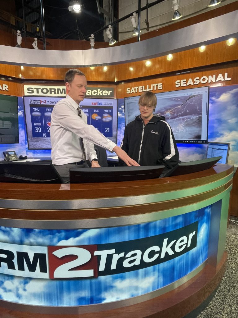 Herkimer junior Arthur Dadello and WKTV meteorologist Bill Kardas interacting on set