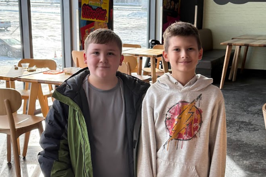 Two students posing together in dining area on field trip