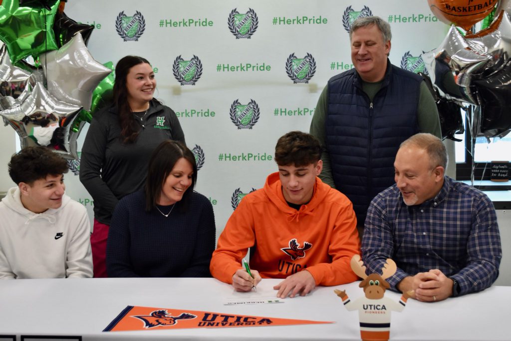 Zachary Petucci with family and coaches signing commitment letter