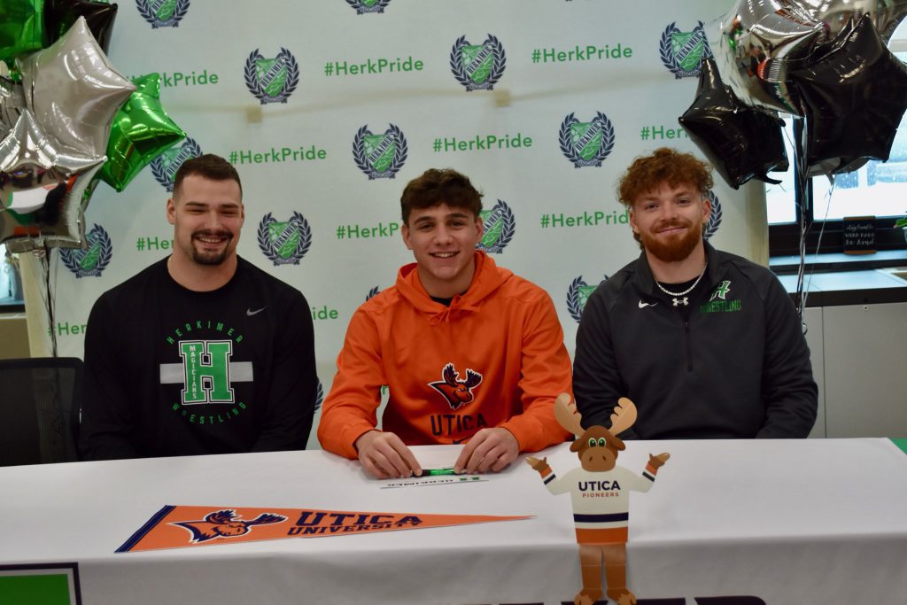 Zachary Petucci with football coaches at commitment singing